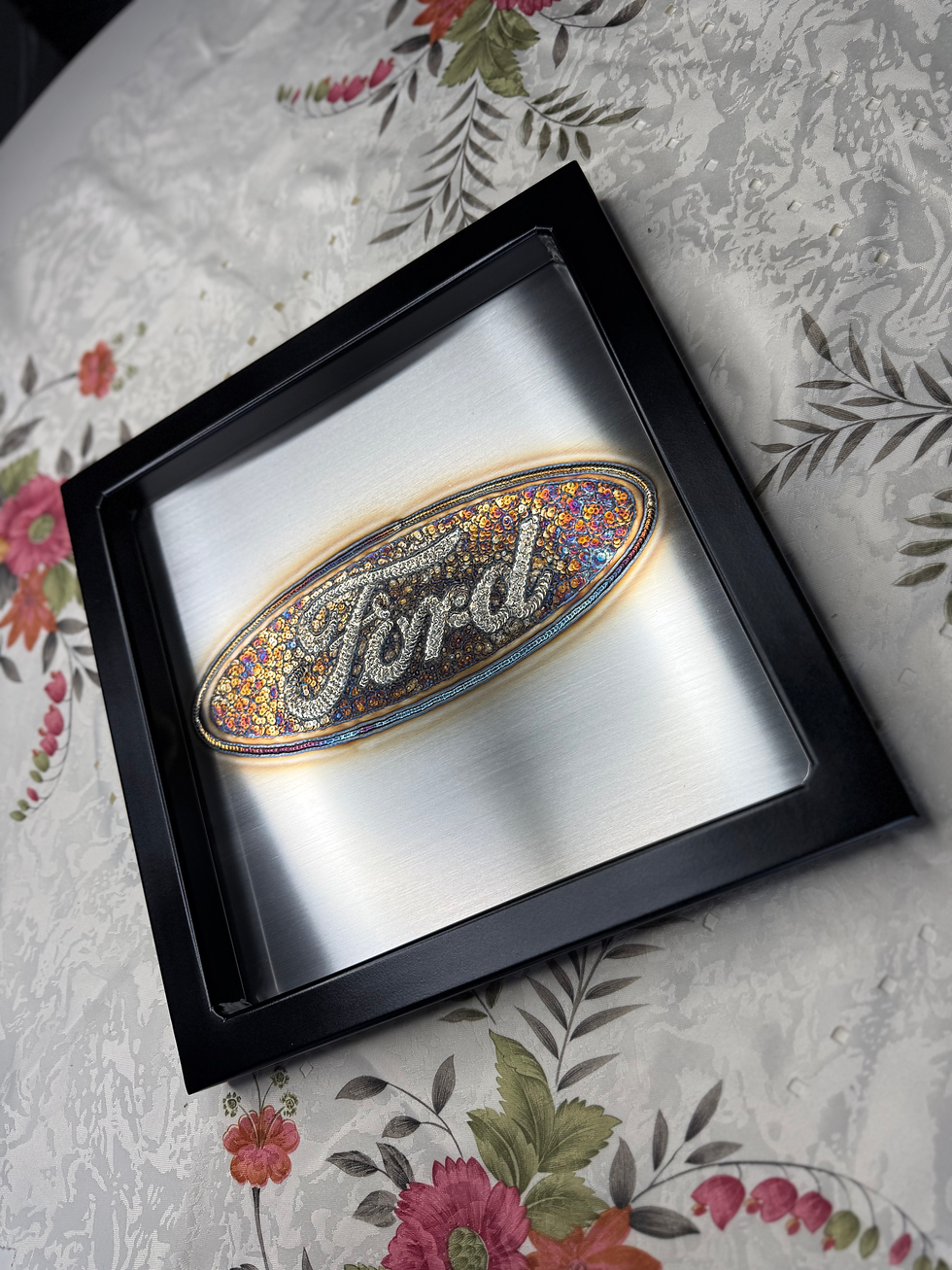 Thumbnail: colorful Ford logo in tig weld art framed in black painted tubing right side view