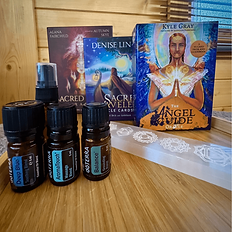 Angel and oracle card decks, doTERRA essential oils and a selenite wand, representing the additional therapies available for a Personal Gong Bath and More