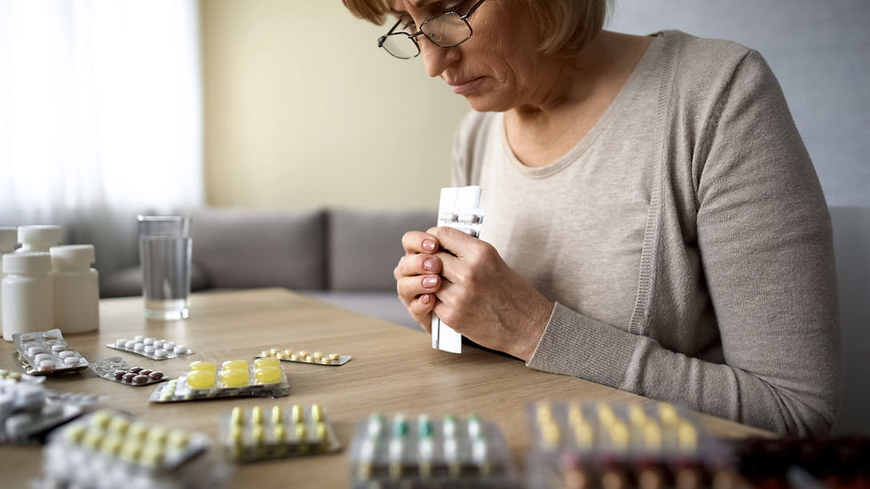 woman looking at medication packets on table