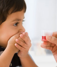Kid hands covering mouth with liquid medicine