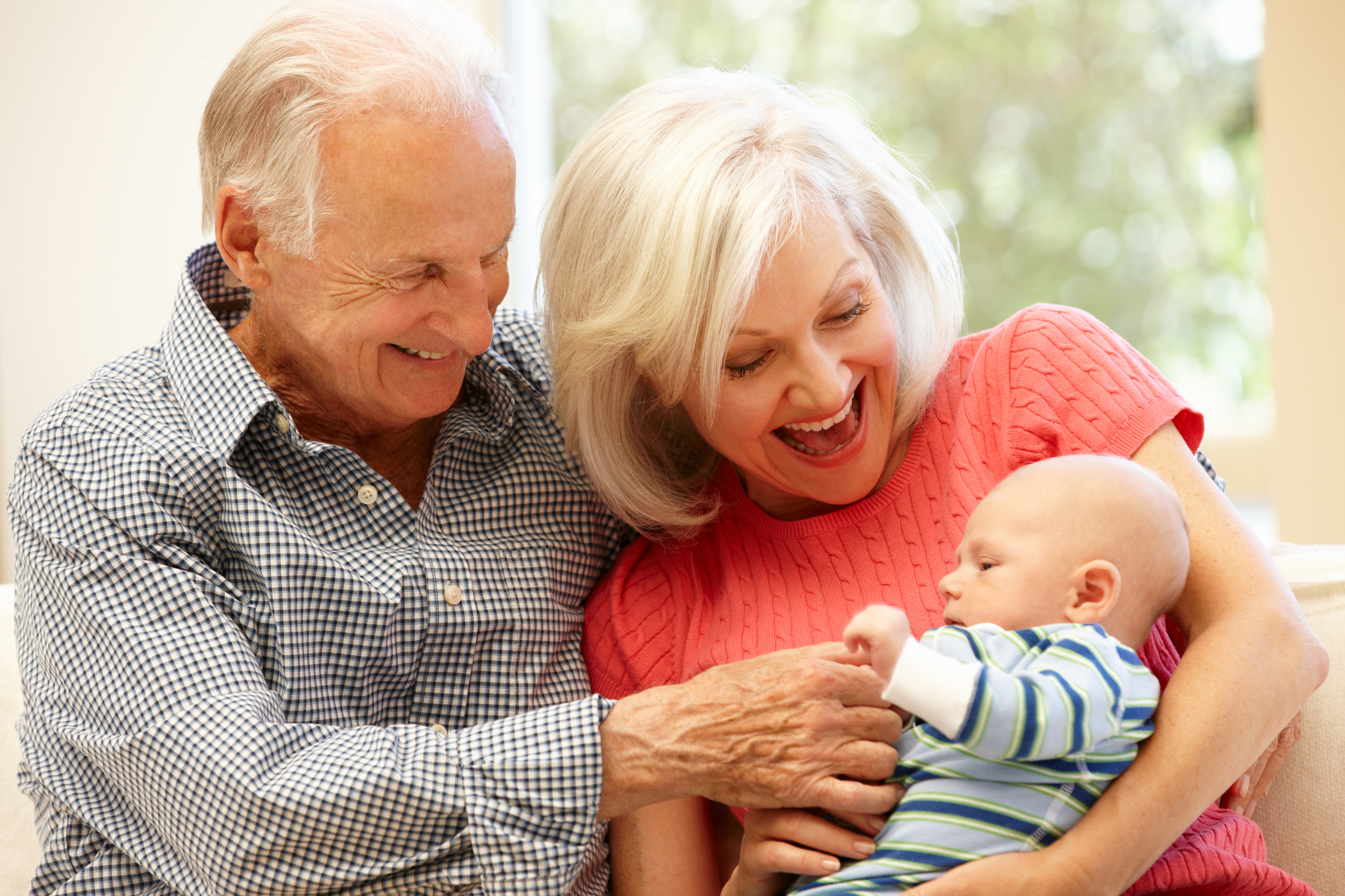 grandparents holding their infant grandchild
