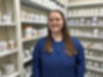 Mount Gay Pharmacy staff member smiling in front of shelves