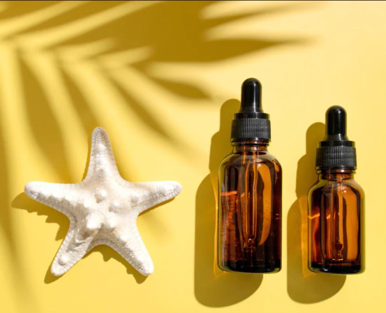 starfish and amber dropper bottles on blank yellow background