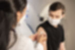 pharmacist administering vaccine to teen