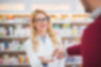 pharmacist smiling while helping patient
