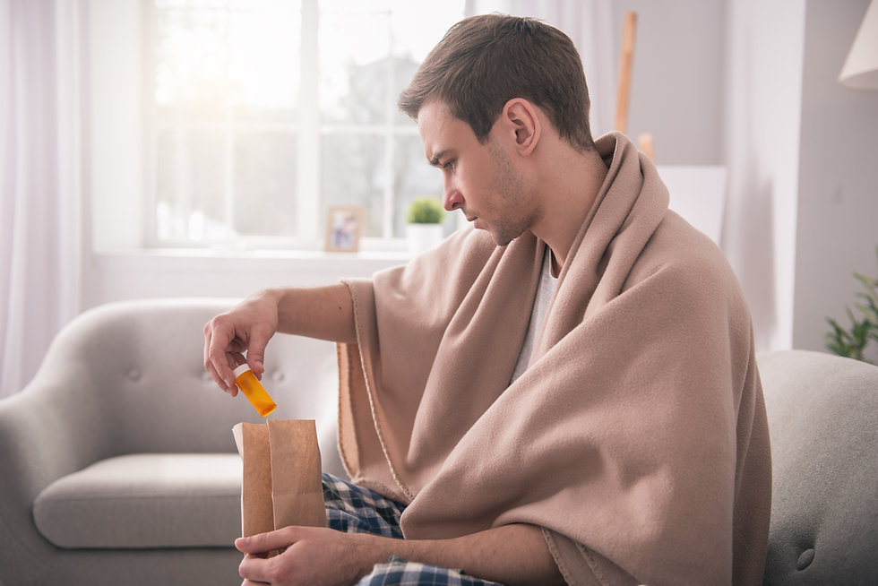 man sitting on couch looking at prescription