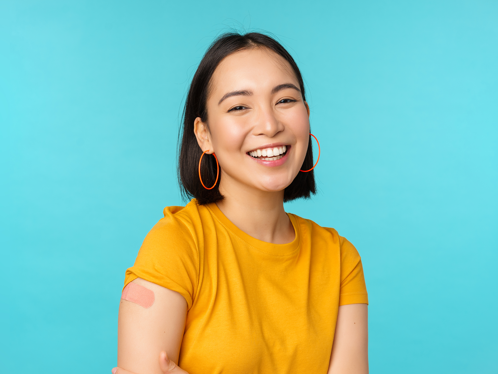 happy female with vaccine bandage