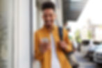 young man with backpack smiling at phone