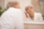 senior_woman_skin_concerned_wrinkles_face_mirror_dermatology.jpg