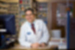 smiling pharmacist leaning on counter