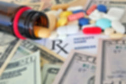 spilled pill bottle on American currency