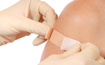 Putting bandaid on patient's arm