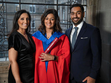 Naeema, wearing red graduation robes, with her son and daughter at her sides, accepted her honorary degree from the University of Edinburgh.