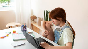 Student using a laptop for online homework help and academic study assistance.