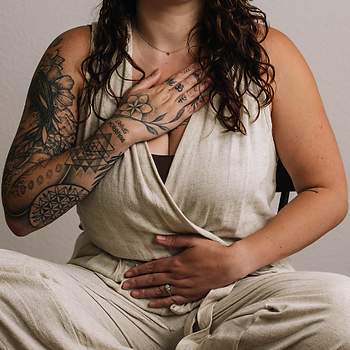 Carmen demonstreert ademwerk met hand op hart en buik
