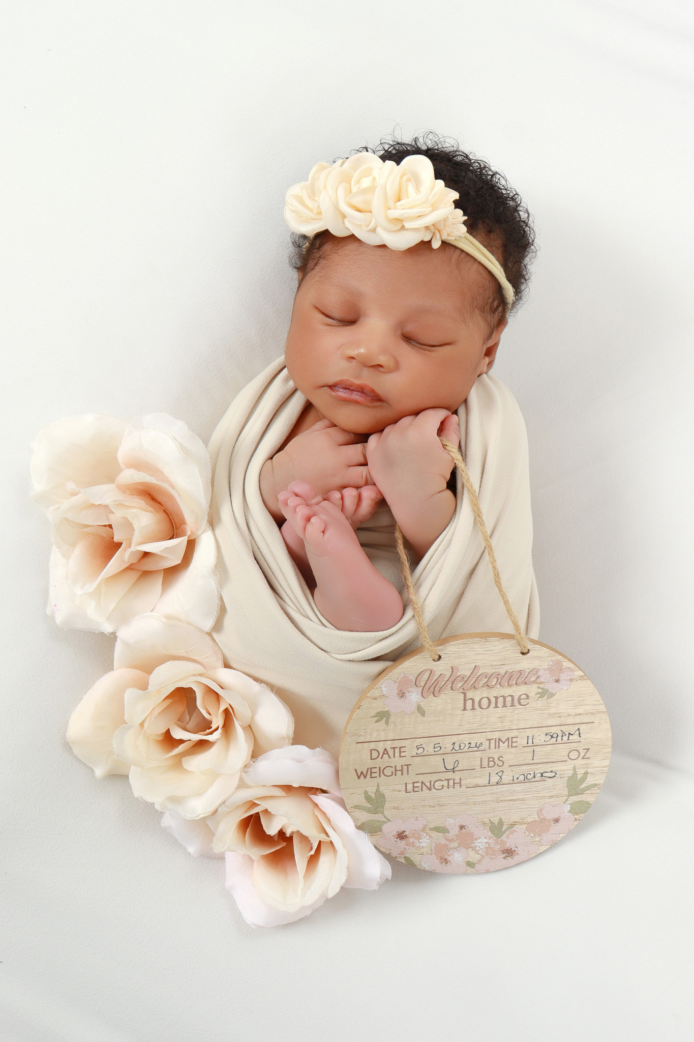 Newborn portrait with cream flowers