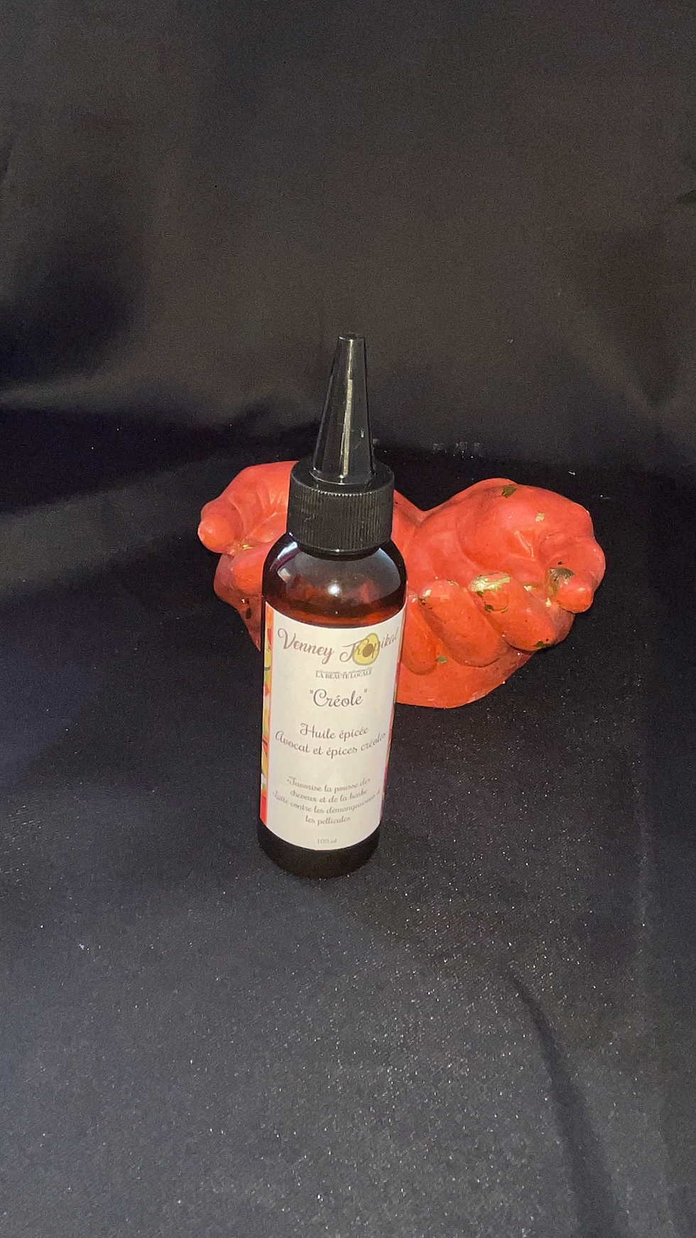 Huile visage Honey Rose visible devant les mains rouges et noires, MamBeautyShop