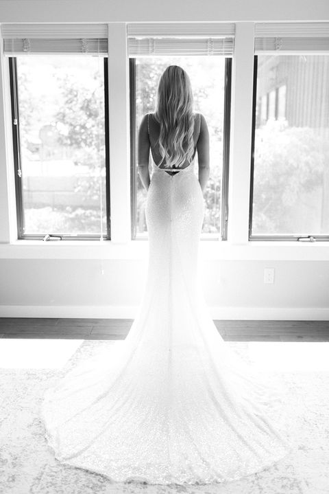 A black & white photo of a bride looking out the window at LARC HILL prior to saying her vows.