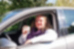 woman in car showing her driver’s licence