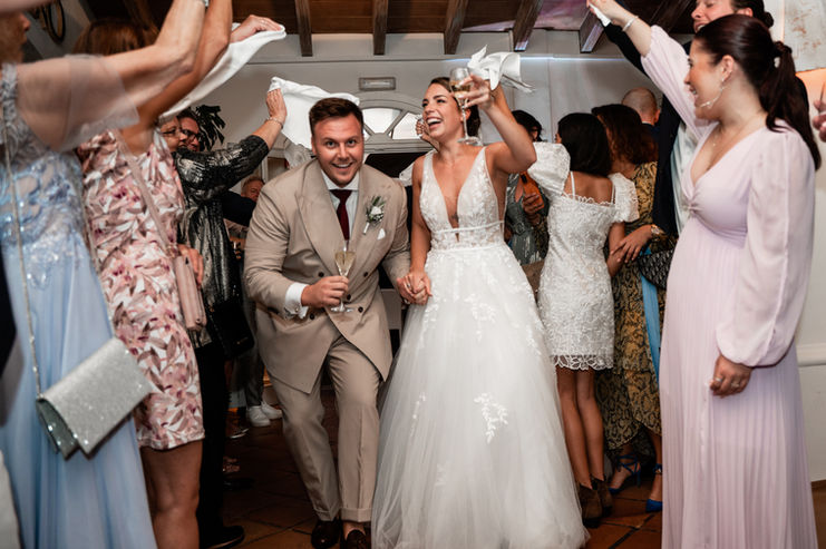 Hochzeitspaar tanzt fröhlich mit Gästen