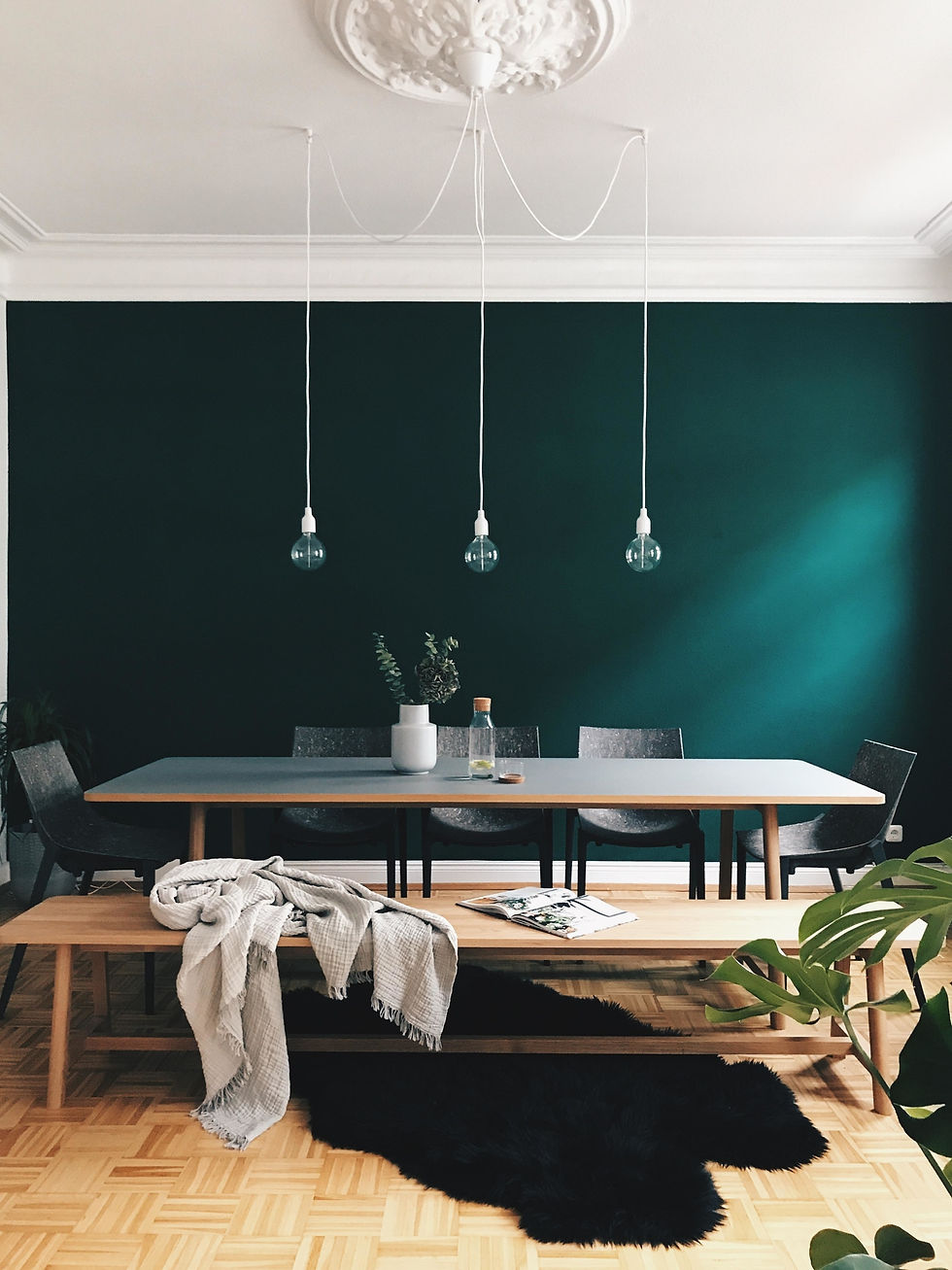 Comedor clásico moderno, pared en verde esmeralda y techos en blanco,donde se combinan roseton en techo con la sencillez de una lámpara artesanal con bombillas