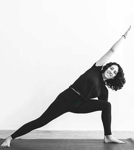 Lena dressed in black doing Extended Side Angle pose