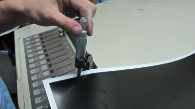 Hand inspecting paper texture and GSM before printing.