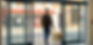 Blind man with guide dog navigating automatic doors independently.