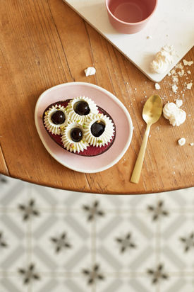 Photographe culinaire d'une glaces posé dans une assiette rose sur une table en bois.