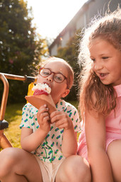 Photographie lifestyle en extérieur avec des petites filles qui mangent une glace de la marque de Brest Jampi