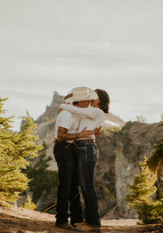 couple kissing in front of oregon mountains 
