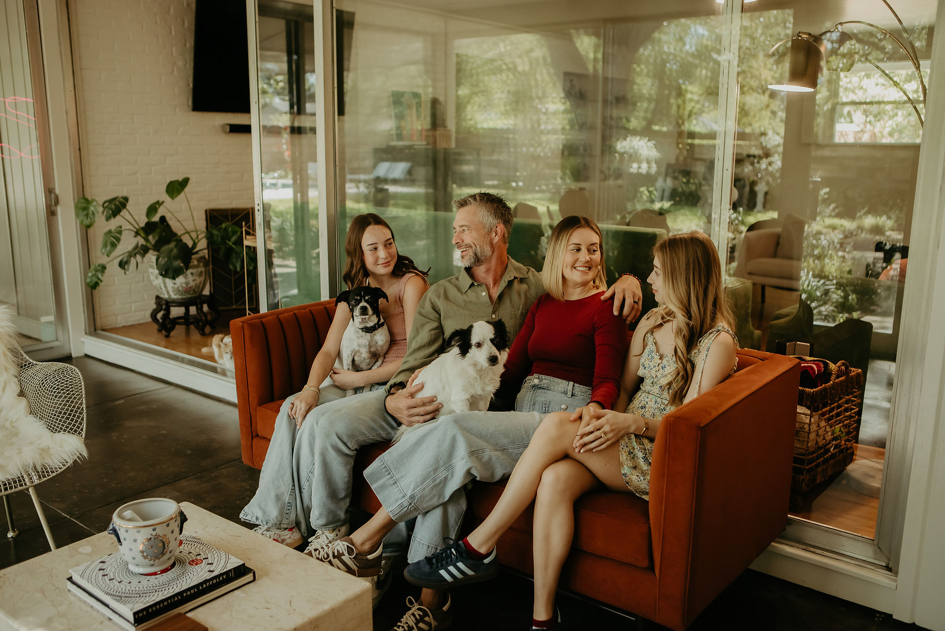 family sitting on a couch together holding dogs natural photo