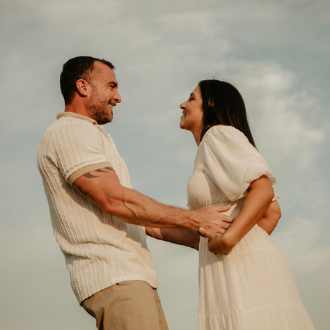Couple embracing with sky and clouds behind
