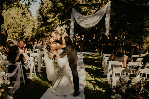 bride and groom kissing down the isle