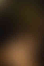 Woman holding plant above her head for photo with sun coming through and shadow falling on her face