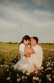 Couple kissing in a field of flowers, couples, engagements, sunset background.