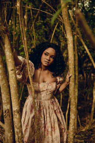 Woman leaning through the trees in Belton Texas forest for moody portrait
