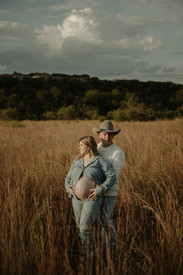 Cowboy hat maternity photo in Austin field with glowing horizon