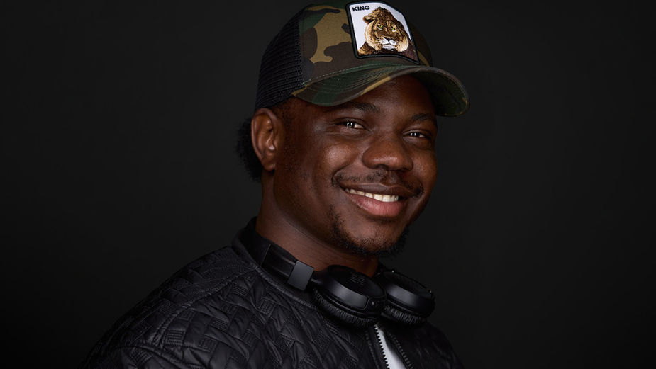 Professional actor headshot of a smiling man wearing a cap and casual clothing against a black background. A bright and approachable portrait, perfect for personal branding, LinkedIn, and social media. Photo by North Star Images.