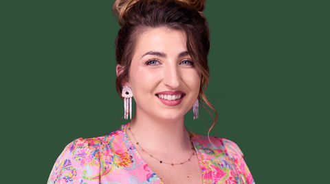 Professional headshot of a woman wearing a colourful dress against a green background. A bright, confident and approachable portrait, perfect for personal branding, LinkedIn, and social media. Photo by North Star Images.