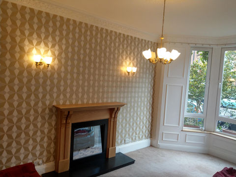 Painted living room with wallpaper on the future wall
