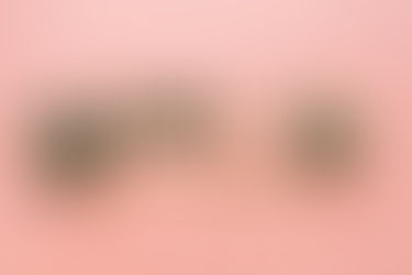 tessere in legno che compongono la scritta cbd is the remedi su sfondo rosa e due foglie di canapa sativa a destra e sinistra
