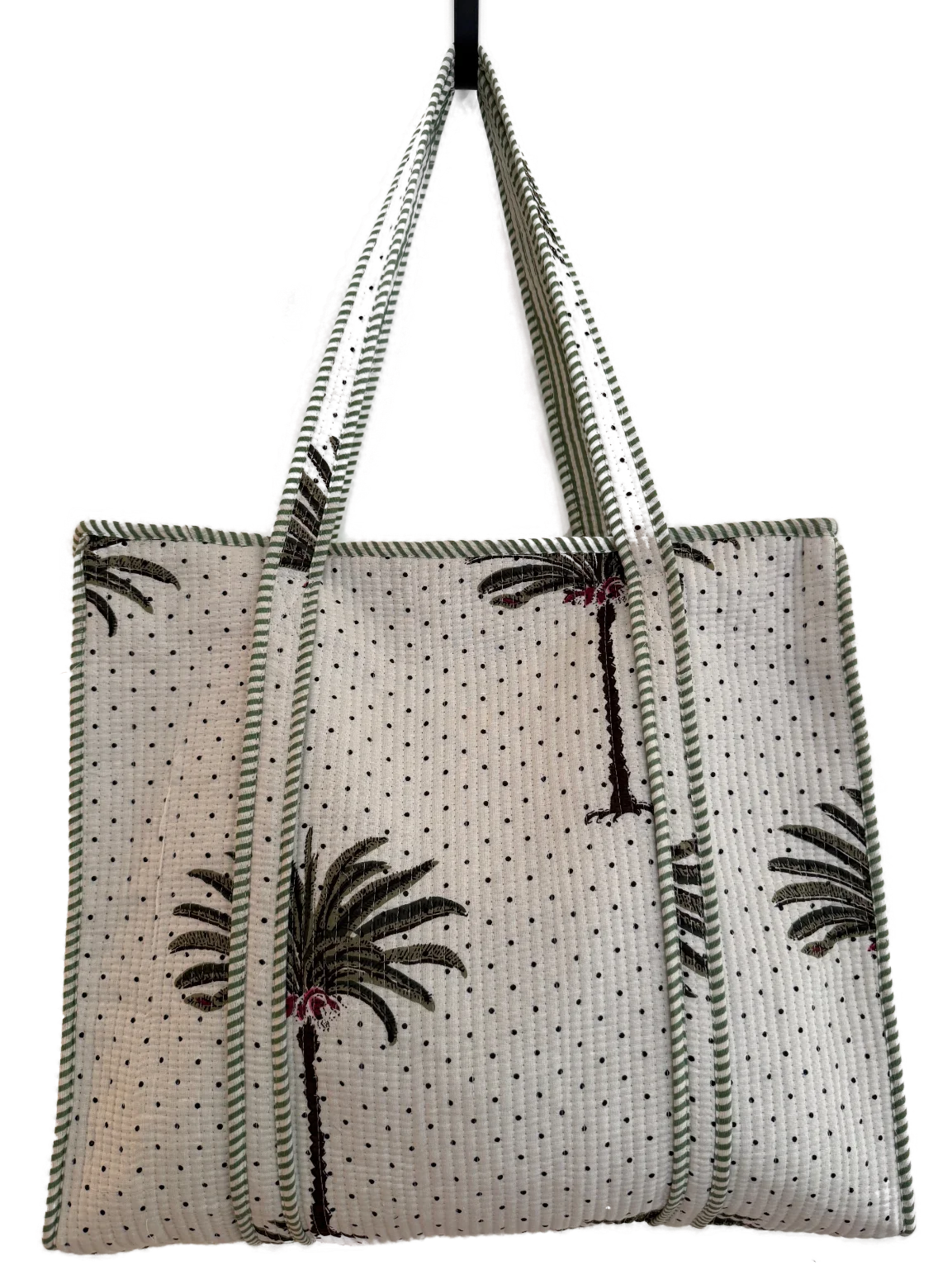 a minimal quilted totebag with a palm motif and dotted pattern.