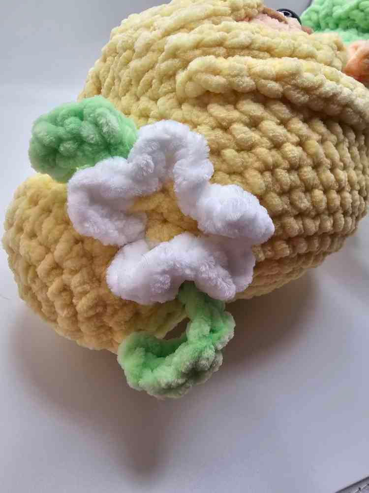 Amigurumi fairy head with yellow hair and white flower
