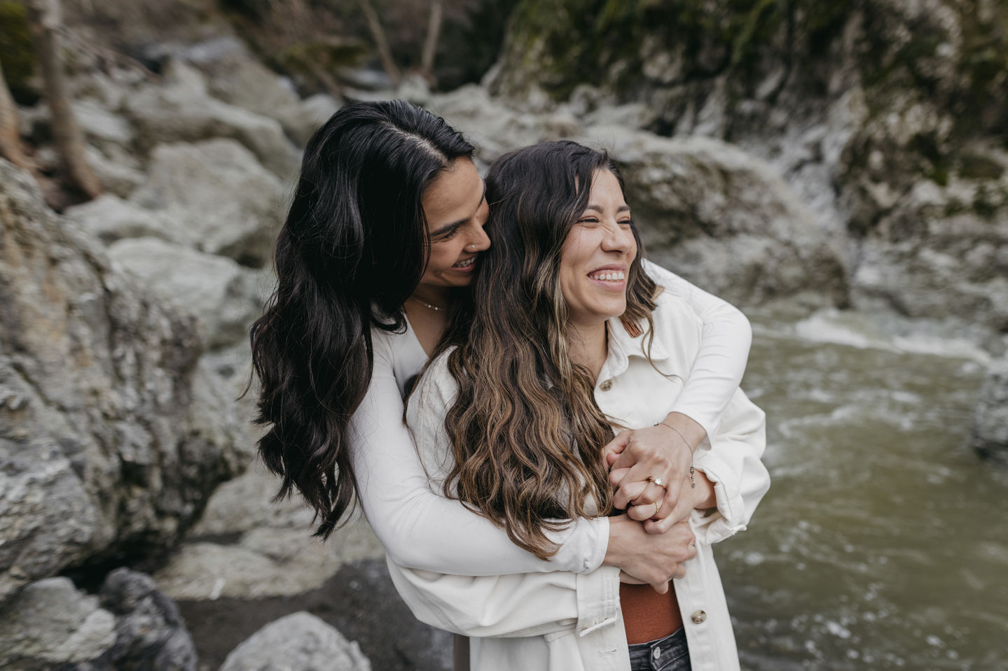 lesbian couple laugh and hug during their engagement session in sunol at little yosemite