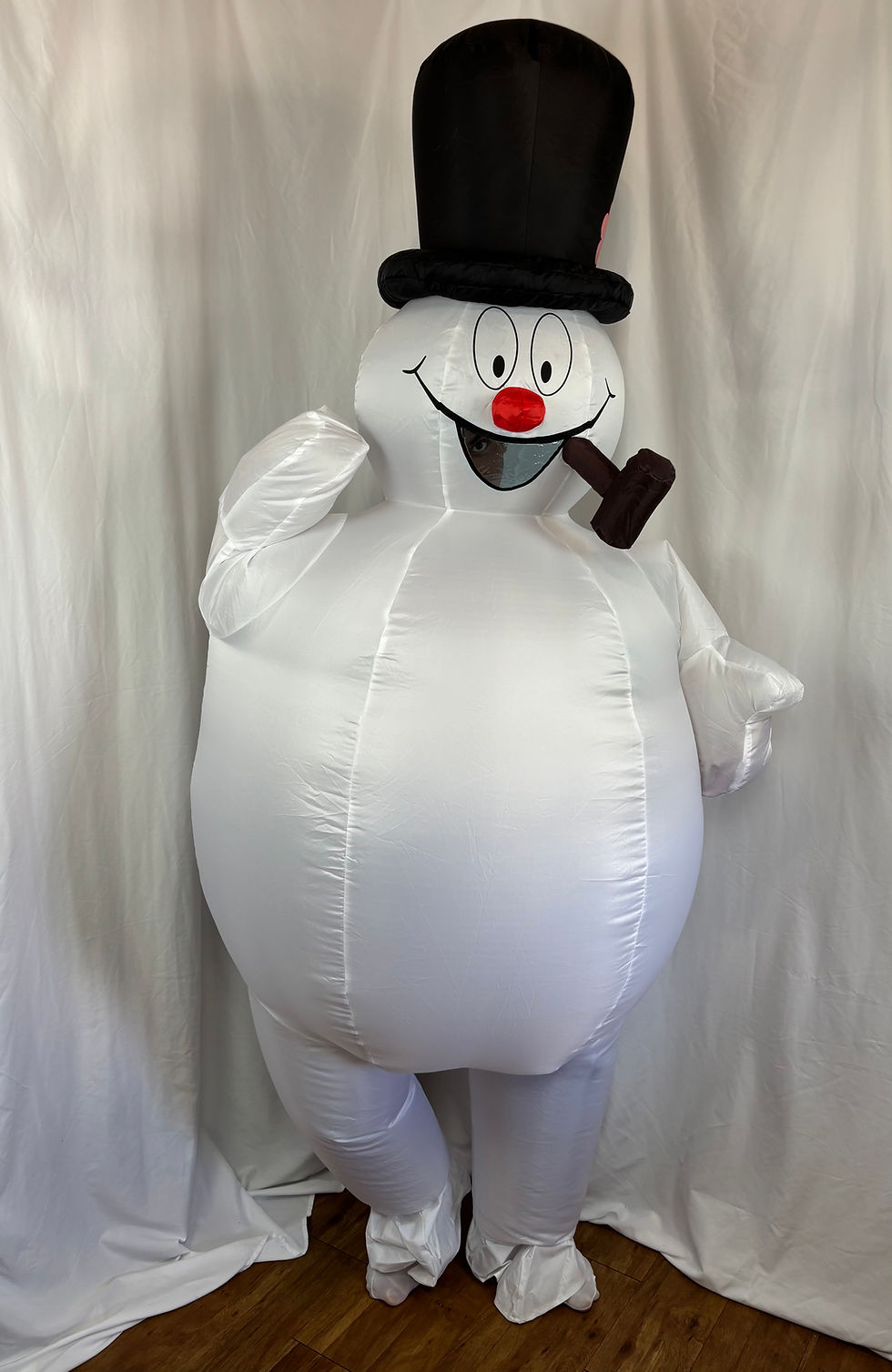 Adult wearing an inflated white cartoon snowman mascot costume for a Christmas party.