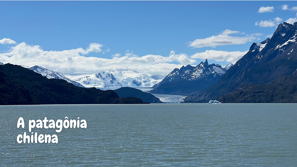 Paisagem da Patagônia Chilena com o Lago Grey, montanhas rochosas e o Glaciar Grey ao fundo sob um céu azul.