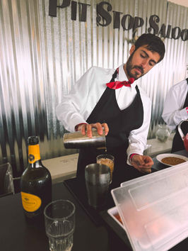 Los Angeles mixologist preparing themed signature cocktails at a branded event activation. Working from a custom beverage station, the mixologist creates immersive drink experiences that complement themed parties, experiential marketing events, and private celebrations throughout Los Angeles.