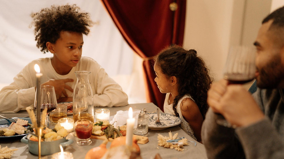 Family with children gathered around the table during Thanksgiving dinner at home, showing why hosts should plan seating, dining space, food service, children’s needs, drinks, and the flow of the house before guests arrive so everyone can relax and spend more time together during the holiday.