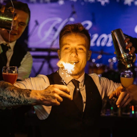 A flair bartender in Los Angeles performs an exciting fire cocktail show while preparing handcrafted drinks for guests at an upscale evening event. Flair bartending entertainment combines fire performance, premium cocktail service, interactive guest engagement, and luxury bar experiences for corporate events, cocktail receptions, VIP parties, and private celebrations.